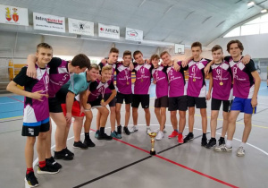 Mistrzostwa Powiatu w Piłce Ręcznej Chłopców - drużyna chłopców z medalami i pucharem na sali gimnastycznej.