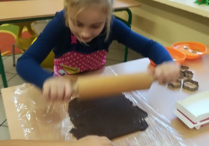 Kl. 1a - dziewczynka wałkuje ciasto na pierniki.