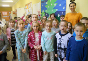 Dzień piżamowy - uczniowie klasy 1 w piżamkach z wychowawczynią w sali lekcyjnej.