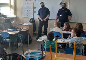 Policjanci w sali lekcyjnej klas młodszych.