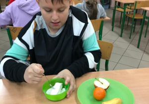Uczeń kroi owoce potrzebne do przygotowania owocowej tortilli