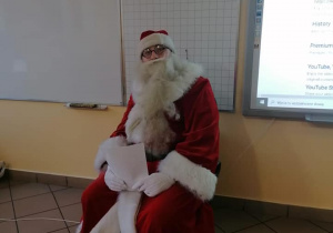 Mikołaj siedzi na fotelu w sali lekcyjnej.