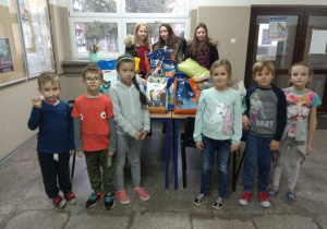 Uczniowie klasy 1a i 7b SP 12 w Zduńskiej Woli podczas zbiórki karmy i akcesoriów dla zwierząt na korytarzu szkolnym przy sali gimnastycznej.